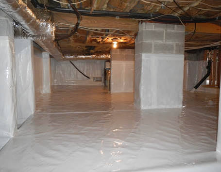 A fully encapsulated Raleigh-area crawl space with white polyethylene vapor barrier covering the floor and piers