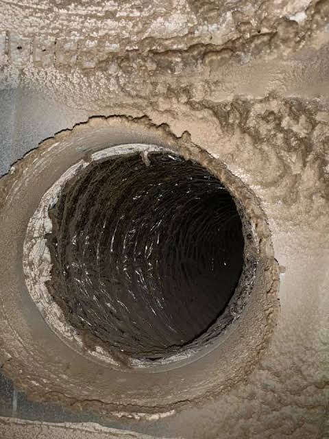 Dirty, deteriorating HVAC ductwork in a Raleigh-area attic showing dust buildup and worn insulation